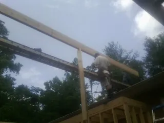 Carpenter setting a ridge beam over a new addition frame — Ice Dam Removal by Roofing Brothers in Lenoir