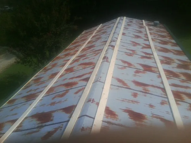 Rusted metal roof panels with new wood purlins before replacement — Storm Damage Roof Repair in Lenoir by Roofing Brothers
